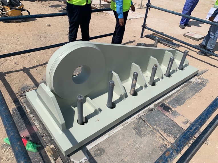 Base plate with shear key positioned over anchor bolts on site.